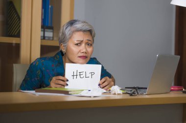umutsuz ve stresli çekici orta yaşlı Asyalı kadın yardım için yardım isteyen tutan stresli overworked ve sömürülen bilgisayar ofis masasında stres acı çalışan