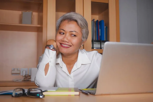 Természetes életmód irodai portréja vonzó és boldog sikeres érett ázsiai nő dolgozik a laptop számítógép asztal mosolygós magabiztos a vállalkozó siker — Stock Fotó