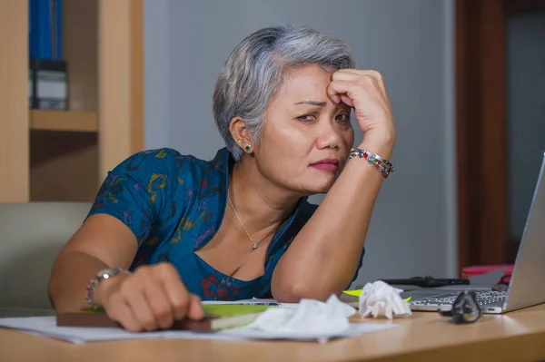 Γραφείο lifestyle πορτρέτο του λυπημένο και καταθλιπτική ώριμη ελκυστική Ασίας γυναίκα που εργάζεται σε φορητό υπολογιστή γραφείο τόνισε και κουρασμένο αίσθημα συγκλονισμένοι και χωρίς κίνητρο — Φωτογραφία Αρχείου