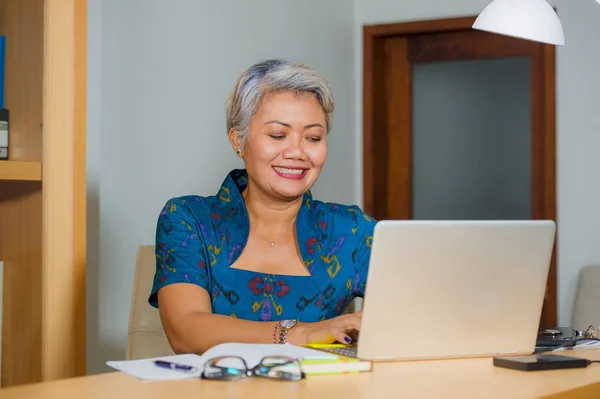 Attraente e felice successo di mezza età donna asiatica che lavora alla scrivania del computer portatile sorridente fiducioso indossando abito elegante nel successo aziendale finanziario — Foto Stock