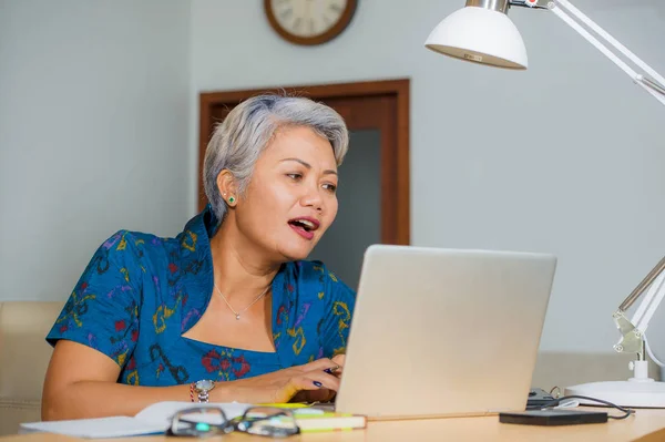 Ελκυστική και ευτυχισμένη επιτυχημένη μεσήλικες ασιατικές γυναίκες που εργάζονται σε φορητό υπολογιστή γραφείο χαμογελαστός γεμάτος αυτοπεποίθηση φορώντας κομψό φόρεμα σε οικονομική επαγγελματική επιτυχία — Φωτογραφία Αρχείου