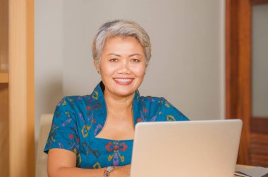  Mutlu ve çekici zarif orta yaşlı Asyalı iş kadını ofis bilgisayar masasında gülümseyerek çalışan yaşam tarzı portre olumlu ve başarılı duygu