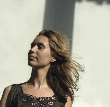 Çekici ve güzel profesyonel model kadın pahalı tasarım elbiseler ve sarı saçlar giyiyor güzellik moda konseptiyle rüzgarda savruluyor.