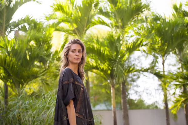 Joven hermosa mujer modelo profesional con costoso diseño de vestido largo de gama alta caminando en el fondo tropical en concepto de moda de belleza —  Fotos de Stock