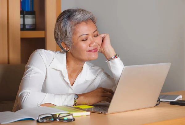 Retrato do estilo de vida do trabalho corporativo da mulher asiática de meia-idade atrativa feliz e bem sucedida que trabalha na mesa do computador portátil do escritório satisfeita e eficiente no sucesso do negócio — Fotografia de Stock