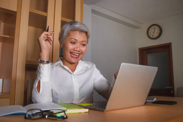 Lavoro aziendale stile di vita ritratto di felice e di successo attraente donna asiatica di mezza età che lavora alla scrivania del computer portatile ufficio soddisfatto ed efficiente nel successo aziendale — Foto Stock