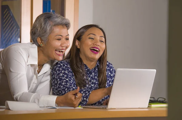 Natural lifestyle portrait of two business partners or work colleagues women collaborating and coworking happy and cheerful at office laptop computer desk — Stock Photo, Image