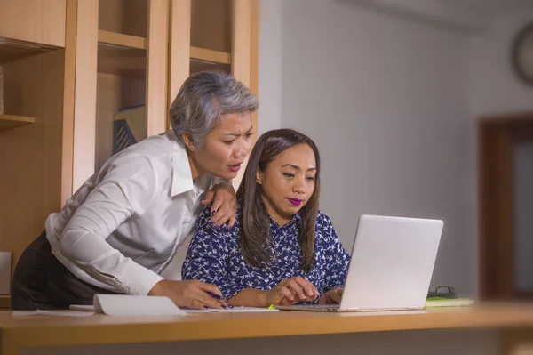 Twee vrouwelijke collega's of zakenpartners werken samen aan het lezen van laptop computer in werk samenwerking en samenwerking — Stockfoto