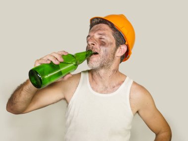 susuz ve yorgun yapıcı işçi veya inşaatçı adam güvenlik kaskı içinde stüdyoda izole iş molası sırasında ferahlatıcı soğuk bira şişesi içme yorgun hissediyorum