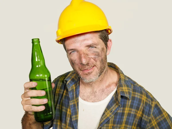 Porträt eines durstigen und müden Bauarbeiters oder Bauarbeiters mit Schutzhelm, der sich erschöpft fühlt, kalte Bierflaschen trinkt und sich in der Arbeitspause erfrischt — Stockfoto