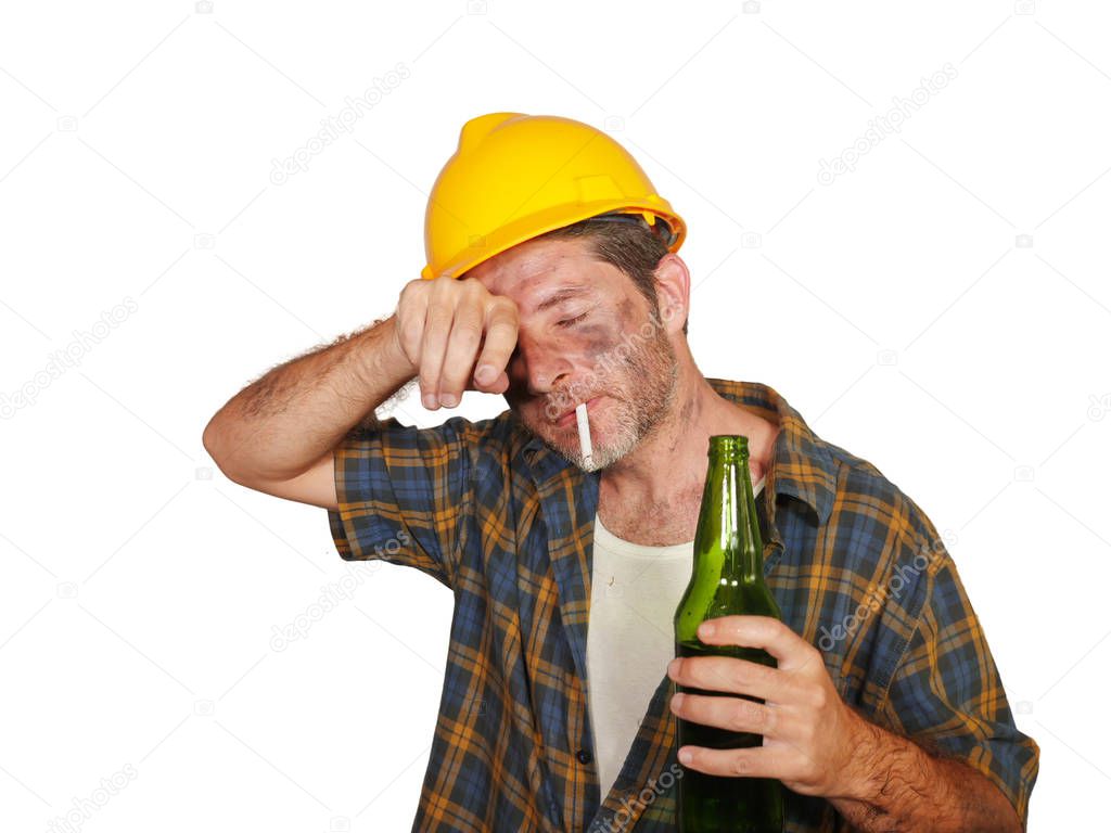 portrait of thirsty tired and exhausted constructor worker or builder man in safety helmet feeling exhausted holding cold beer bottle refreshing during work break