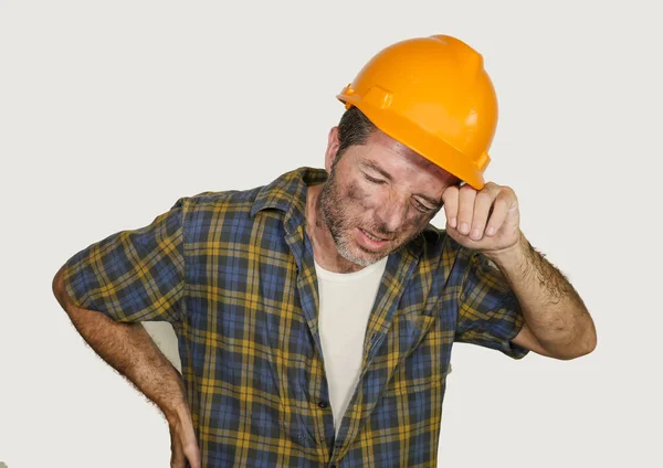 Trabajador de la construcción molesto y cansado o reparador con casco constructor que se queja de sufrir dolor en la parte inferior de la espalda sensación de agotamiento después de trabajar duro — Foto de Stock