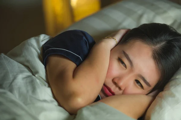 Красивая грустная и депрессивная азиатская китаянка просыпается в постели поздно ночью страдает от кризиса тревоги и депрессии, чувствуя отчаяние после разрыва отношений — стоковое фото