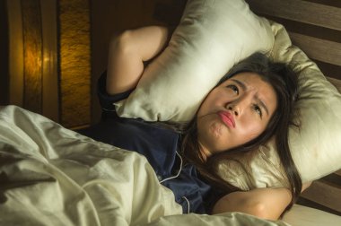 Genç uykusuz güzel ve korkmuş Asya Japon kadın yatakta uyanık yatarken uyku korku zombi korku filmi izlerken ve yüz vurguladı sonra kabus acı 