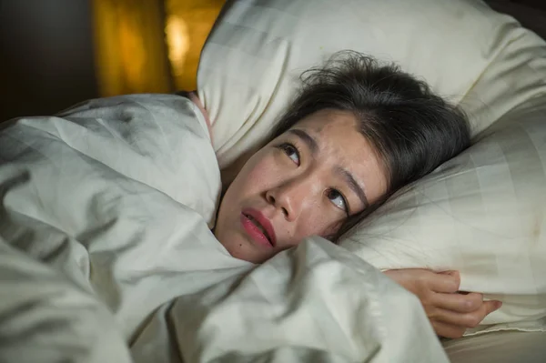 Jonge slapeloze mooie en bang Aziatische Japanse vrouw liggend op bed wakker 's nachts lijden nachtmerrie na het bekijken van Zombie horrorfilm in angst en gestrest gezicht — Stockfoto