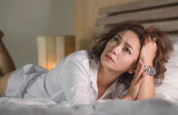 Dramatisches Lebensstil-Porträt einer attraktiven, traurigen und depressiven Frau mittleren Alters um die 50, die sich allein im Bett aufgeregt fühlt und unter Depressionen und Angstzuständen leidet — Stockfoto