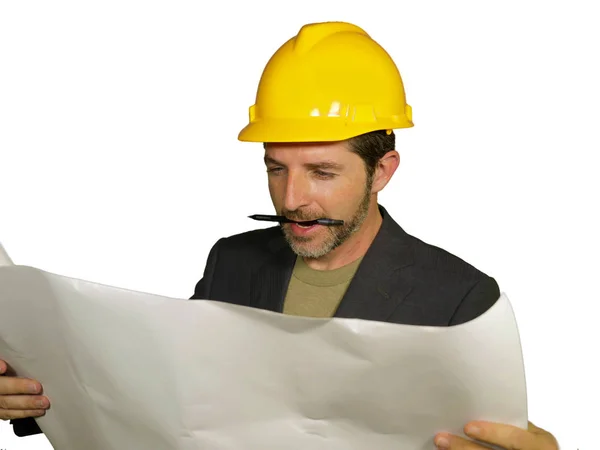 Retrato corporativo de jovem atraente e bem sucedido engenheiro industrial ou arquiteto no capacete do construtor de segurança verificando projeto de construção blueprint feliz e satisfeito — Fotografia de Stock