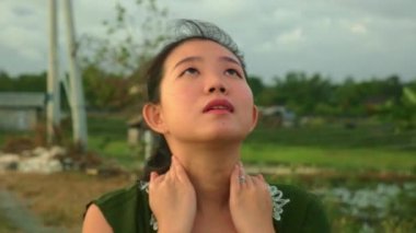 doğada arka planda romantik ve melankolik ruh hali içinde düşünceli ve düşünceli yeşil alanlarda yürüyüş tatillerde genç güzel ve doğal Asyalı Çinli kadın gimbal steadycam çekim