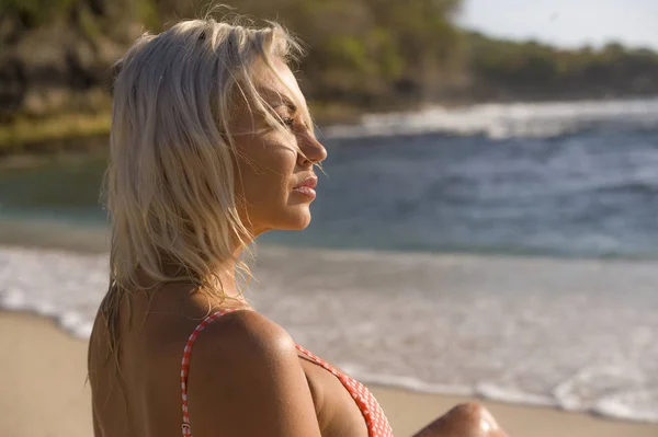 Портрет молодой красивой и сексуальной блондинки в бикини, позирующей счастливой и расслабленной на тропическом пляже во время отпуска — стоковое фото