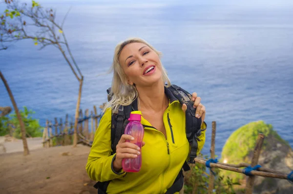 Joven hermosa y feliz excursionista mujer con mochila senderismo en el acantilado de montaña mar explorar destino tropical disfrutar de viajes en solitario trekking aventura vacaciones — Foto de Stock