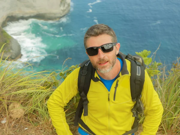 Unga glada och attraktiva sportiga vandrare man med Trekking ryggsäck vandring på Sea Cliff landskap Känn dig fri att njuta av resor flyktbilen utforska natur och miljö — Stockfoto