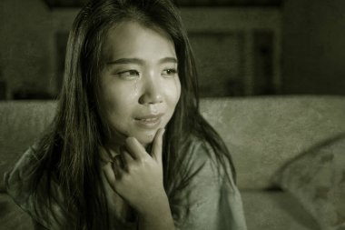 genç üzgün ve depresif Asyalı Japon kadın umutsuz evde kanepede oturan ağlama depresyon sorunu ve anksiyete krizi acı gözyaşları içine patladı