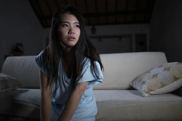 Mladá zoufalá smutná a deprimovaná asijská žena, která seděla doma na pohovce a na pohovce trpící problémem deprese a úzkostná krize cítí osaměle — Stock fotografie
