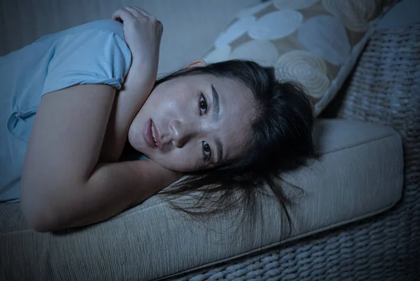 Junge verzweifelte traurige und depressive asiatische Chinesin, die zu Hause auf dem Sofa sitzt und unter Depressionen und Angstkrise leidet, fühlt sich einsam — Stockfoto