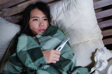 genç güzel hasta ve bitkin Asyalı Koreli kadın soğuk algınlığı ve grip tutan termometre acı battaniye ile örtünme sıcaklık sahip hasta hissi