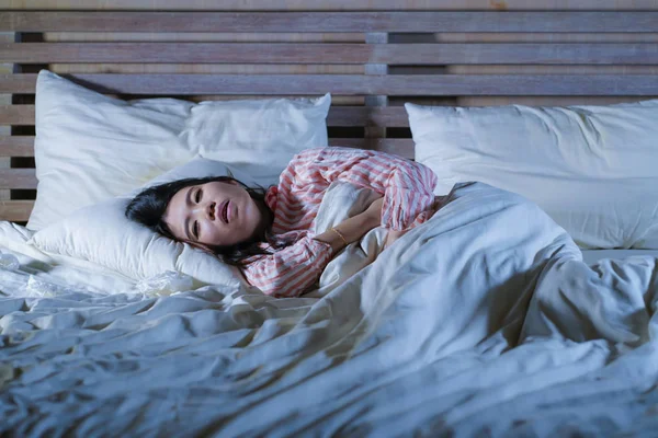 Mladá krásná unavená a nemocná Asijská Japonská žena ležela na posteli doma nemocná trpící studenou chřipkou a teplotním pocitem nedobré a horečné zdravotní péče a zdraví — Stock fotografie