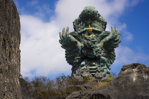 впечатляющий вид Гаруда Wisnu зеленой медной статуи вдохновил в индуистский миф стоял величественный под голубым небом в Индонезии путешествия ориентир
 