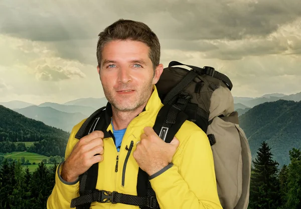 Unga glada och attraktiva vandrare mannen bär ryggsäck poserar glad under fjällvandringen leende njuter vacker natur resa och vandring äventyr — Stockfoto