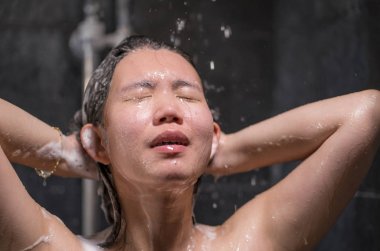 genç güzel ve mutlu Asyalı Koreli kadın 20'li yaşlardan 30'lu yaşlara ıslak ve taze gülümseyen neşeli bir duş alarak saçlarını şampuan ile rahat duygu