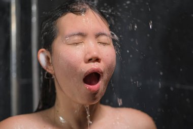 genç güzel ve mutlu Asyalı Çinli kadın 20'li yaşlarda niçin ıslak ve taze gülümseyen neşeli bir duş alarak saçlarını şampuan ile rahat duygu