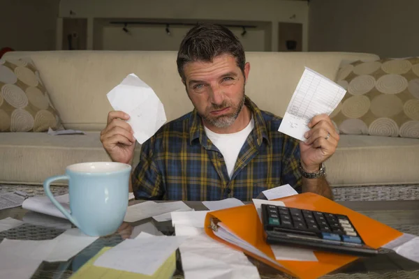 Homem frustrado em casa sala de estar sofá fazendo contabilidade doméstica oprimido e preocupado sofrendo problema financeiro passando por cima de impostos e pagamentos papelada — Fotografia de Stock