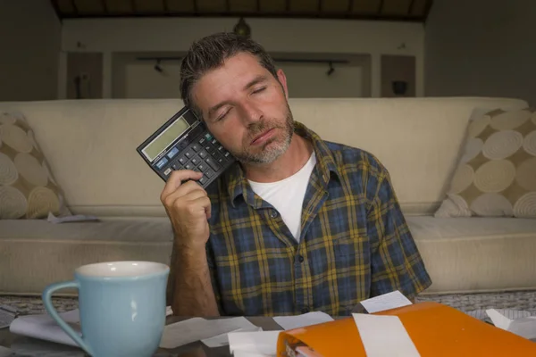 Frustrated man at home living room couch doing domestic accounting overwhelmed and worried suffering financial problem going over taxes and payments paperwork — Stock Photo, Image