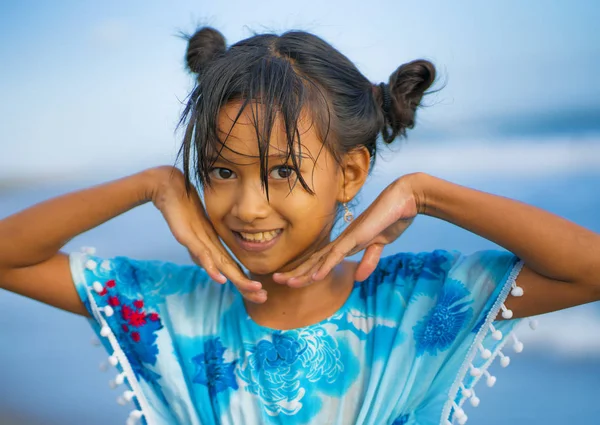 Praia estilo de vida retrato de jovem bonita e feliz menina asiática 8 ou 9 anos com bonito pães duplos estilo de cabelo jogando despreocupado no mar desfrutando de férias — Fotografia de Stock