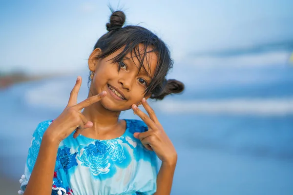 Praia estilo de vida retrato de jovem bonita e feliz menina asiática 8 ou 9 anos com bonito pães duplos estilo de cabelo jogando despreocupado no mar desfrutando de férias — Fotografia de Stock