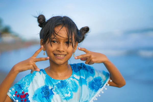 Praia estilo de vida retrato de jovem bonita e feliz menina asiática 8 ou 9 anos com bonito pães duplos estilo de cabelo jogando despreocupado no mar desfrutando de férias — Fotografia de Stock