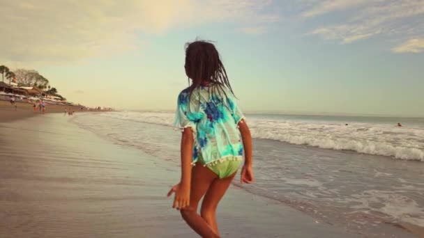 Gimbal 稳定摄像头慢动作跟踪镜头的快乐和兴奋的亚洲印尼女孩运行无忧无虑的海滩上有乐趣在海里享受暑假 — 图库视频影像