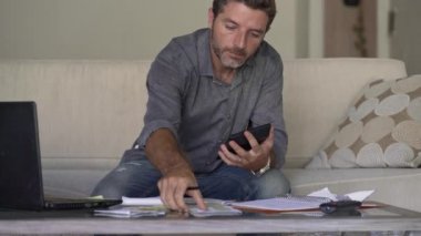 modern dairede iç finans gelir ve vergi evrak sayma hesap makinesi kullanarak oturma odası kanepe kanepe de genç çekici ve meşgul adam muhasebe aylık giderleri ve borç ödemeleri