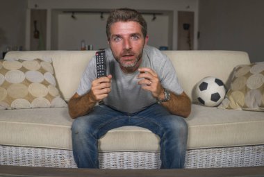 genç çekici sinirli ve heyecanlı futbol taraftarı adam oturma odası kanepede televizyonda futbol oyunu izlerken deli yoğun duygu duygu