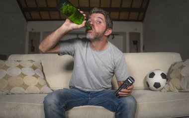 stres ve duygu içme bira şişesi evde kanepede televizyonda futbol oyunu izlerken çekici sinir ve heyecanlı futbol taraftarı adam