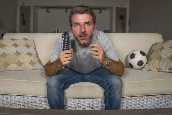 年轻有吸引力的紧张和兴奋的足球支持者男子在电视上看电视在客厅沙发感觉疯狂强烈的情绪 — 图库照片