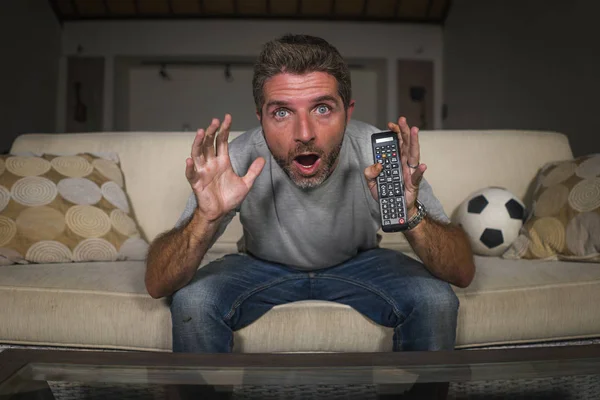 Jeune attrayant nerveux et excité supporter de football homme regardant match de football à la télévision dans le canapé du salon se sentant fou émotion intense — Photo