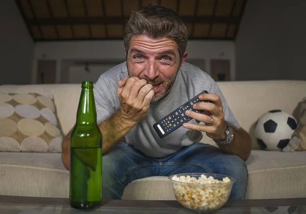 Supporter de football excité homme regardant match de football à la télévision à la maison canapé canapé dans le stress et l'émotion manger du maïs soufflé et boire de la bière mordre les ongles — Photo