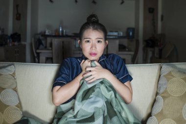 genç güzel mutlu ve neşeli Asyalı Japon kadın Tv komedi filmi veya komik göstermek gülerek ve battaniye ile evde kanepede oturan patlamış mısır yeme izlerken