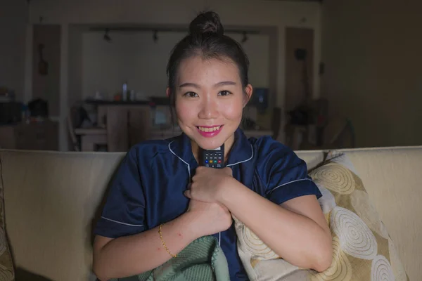 Jeune belle heureuse et détendue asiatique chinois femme à la maison salon assis confortable sur canapé regarder la série télévisée épisode ou romantique comédie film sourire doux — Photo