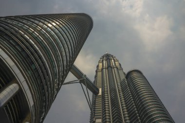 Malezya'da mavi bir gökyüzü üzerinde izole metal cephede güneşi yansıtan çarpıcı Petronas Kuleleri düşük açı görünümü
