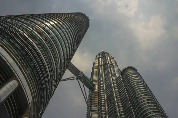 Lage hoek uitzicht van de prachtige Petronas torens reflecterend de zon in de metalen gevel geïsoleerd op een blauwe hemel in Maleisië — Stockfoto